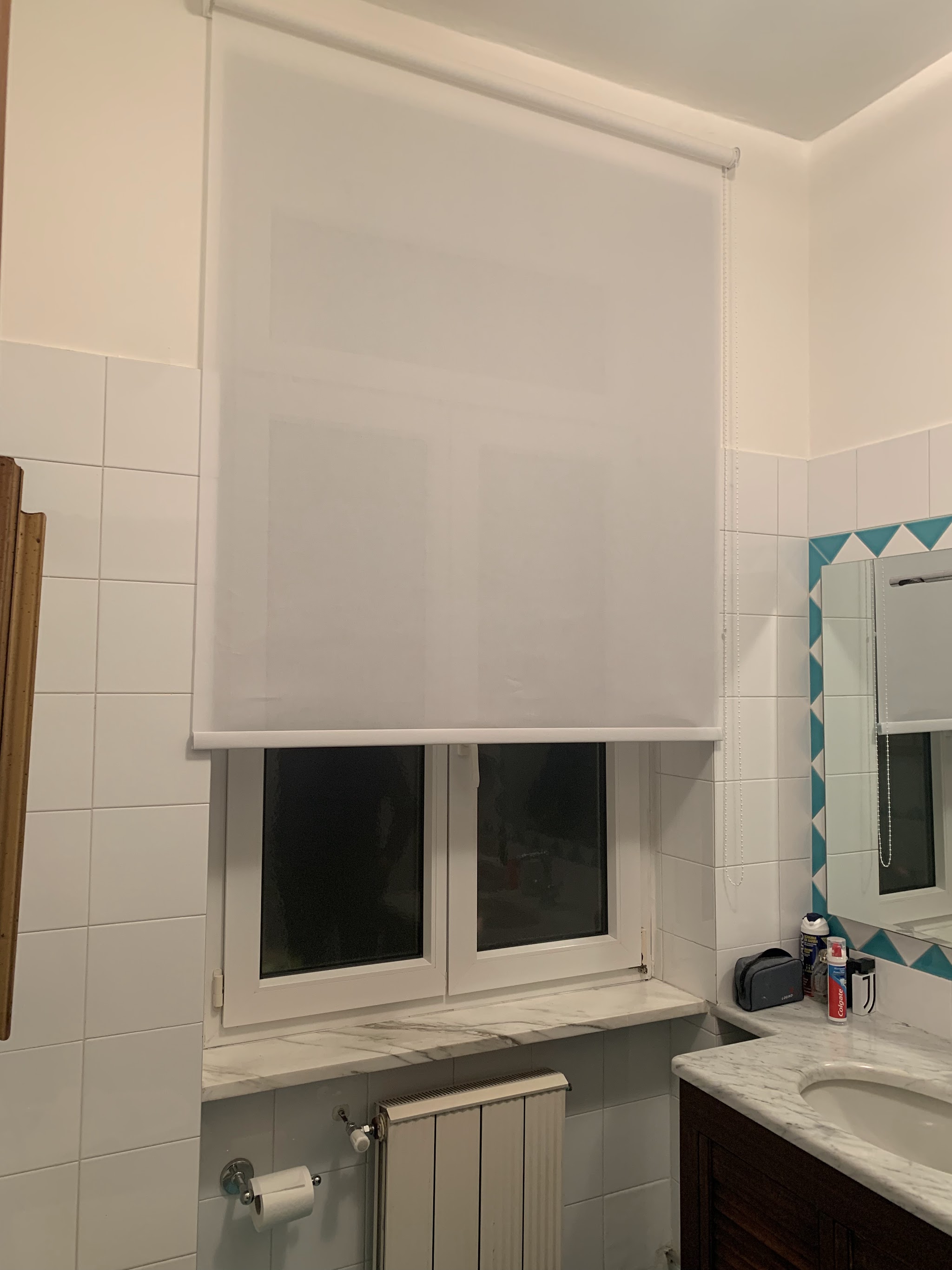 Tenda tecnica bianca a rullo installata in bagno